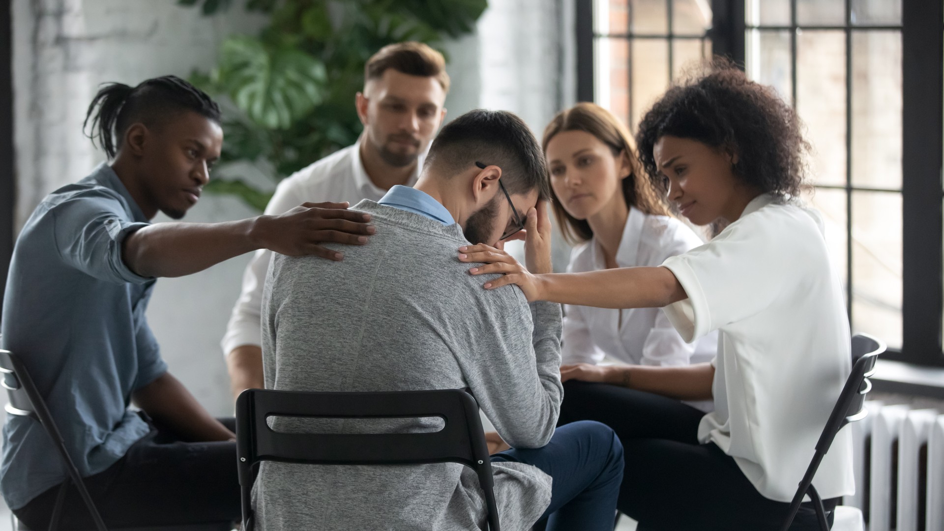 Stressed male get support from diverse people at session